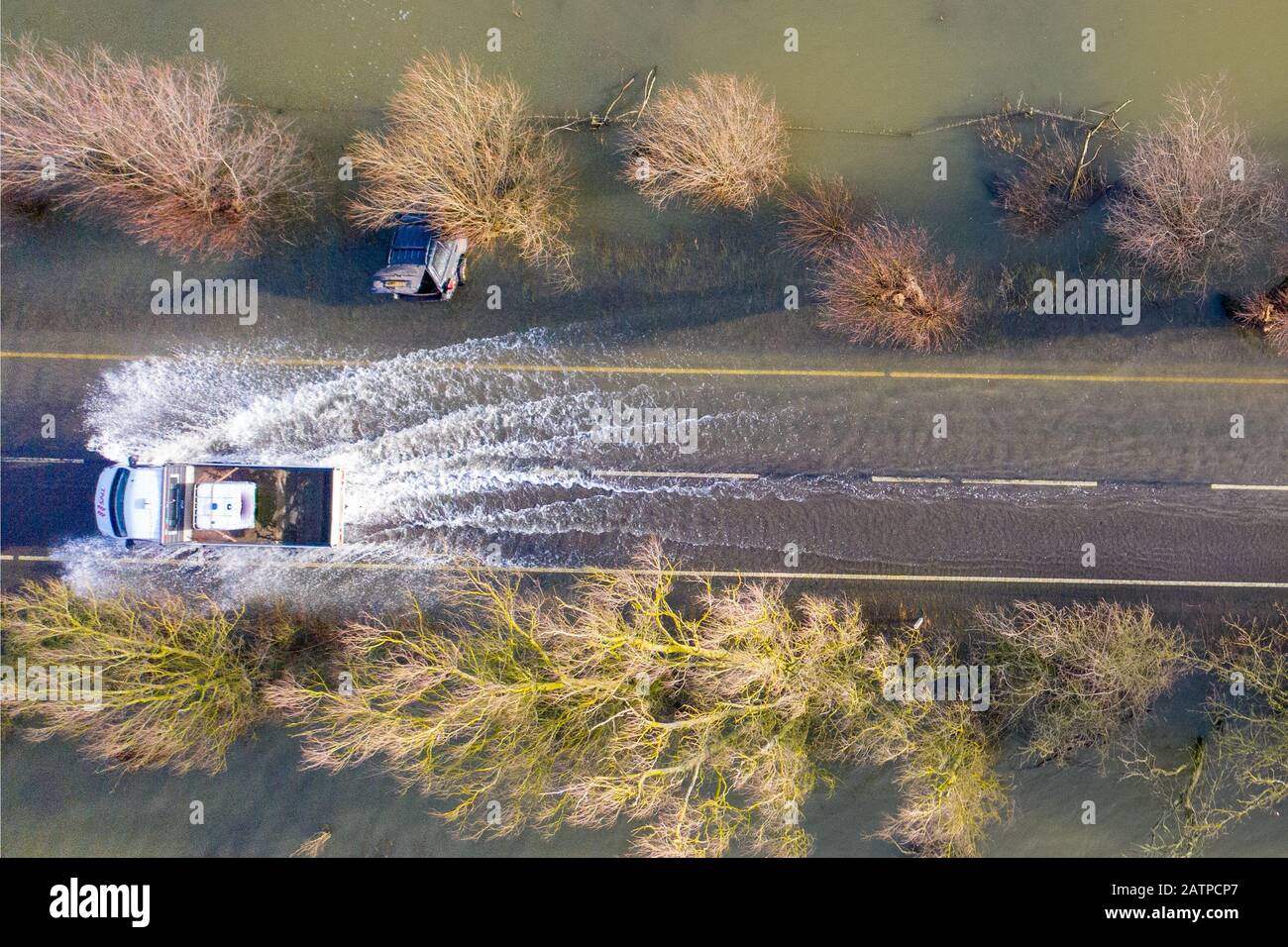 La foto datata gennaio 27th mostra un veicolo che ha guidato oltre le auto che sono state catturate sulla A1101 sul confine Cambridgeshire/Norfolk nelle recenti inondazioni e sono ora immediatamente visibili dopo che le acque alluvionali sono scese. Inondare l'acqua lungo un famigerato tratto di strada a Welney sul confine Cambridgeshire/Norfolk si è placato rivelando oggi un incredibile QUATTRO auto a trefoli (Mon). Gli automobilisti sono stati tutti presi dal lungo e tortuoso tratto di strada, che è stato allagato per due mesi. Quattro persone hanno dovuto essere salvate da una delle automobili da vigili del fuoco dopo che è stato catturato a Welney Wash su Janu Foto Stock