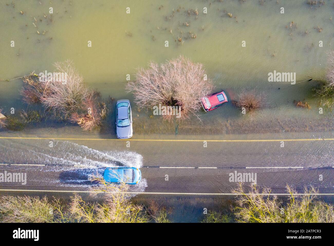 La foto datata gennaio 27th mostra un veicolo che ha guidato oltre le auto che sono state catturate sulla A1101 sul confine Cambridgeshire/Norfolk nelle recenti inondazioni e sono ora immediatamente visibili dopo che le acque alluvionali sono scese. Inondare l'acqua lungo un famigerato tratto di strada a Welney sul confine Cambridgeshire/Norfolk si è placato rivelando oggi un incredibile QUATTRO auto a trefoli (Mon). Gli automobilisti sono stati tutti presi dal lungo e tortuoso tratto di strada, che è stato allagato per due mesi. Quattro persone hanno dovuto essere salvate da una delle automobili da vigili del fuoco dopo che è stato catturato a Welney Wash su Janu Foto Stock