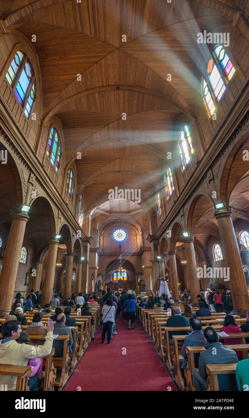 Churchgoers alla Santa Messa di Pasqua a Iglesia San Francisco, chiesa in legno a Castro, Isla Grande de Chiloe, regione di Los Lagos, Patagonia, Cile Foto Stock