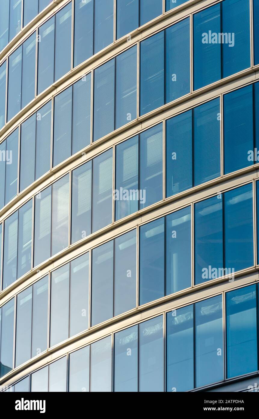 Vista ravvicinata del dettaglio in un moderno edificio in vetro con vetro riflettente e design contemporaneo. Foto Stock