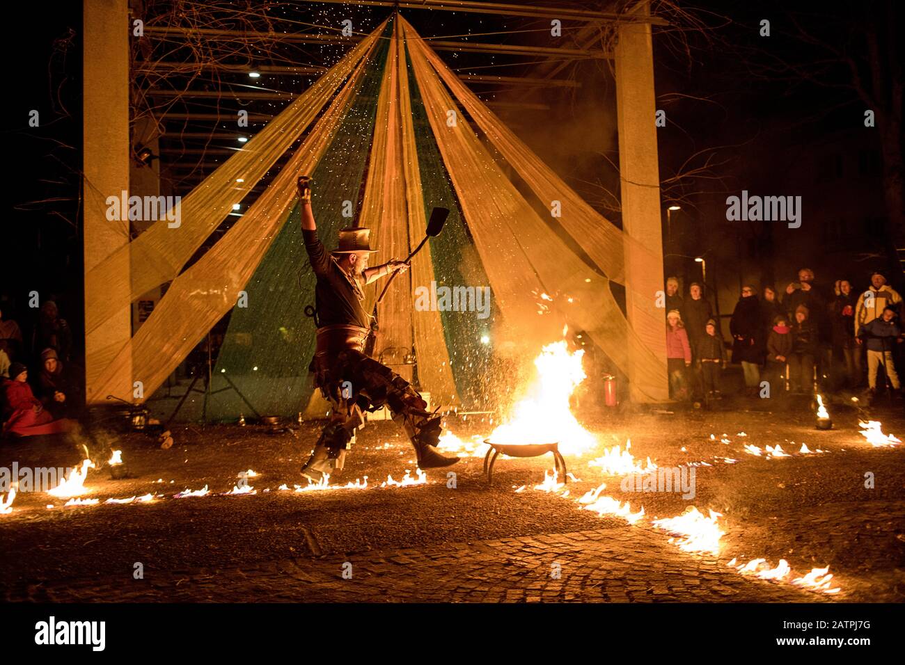 Artista di strada con un bastone che brucia durante la sua pericolosa mostra di fuoco, Ana Mraz, Festival Internazionale Winter Street Theatre a Lubiana, Slovenia Foto Stock