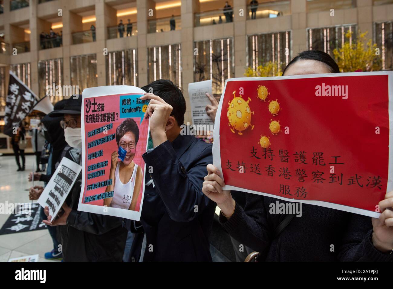 I dimostranti hanno dei cartelli durante la protesta.Decine di manifestanti hanno protestato presso il centro commerciale Landmark di Central chiedendo al governo di Hong Kong di chiudere tutti i confini di Hong Kong, collegandosi con la Cina continentale, per controllare che il mortale virus Corona si diffonda a Hong Kong. Foto Stock