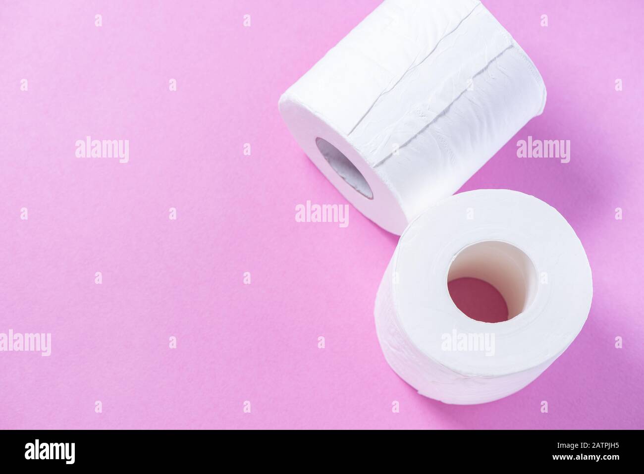 Carta igienica perforata ecologica bianca su sfondo rosa Foto Stock