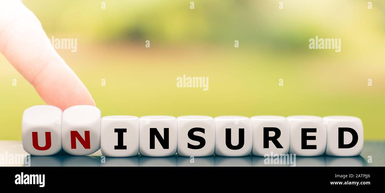 Mano gira dadi e cambia la parola "non assicurato" in "assicurato". Foto Stock