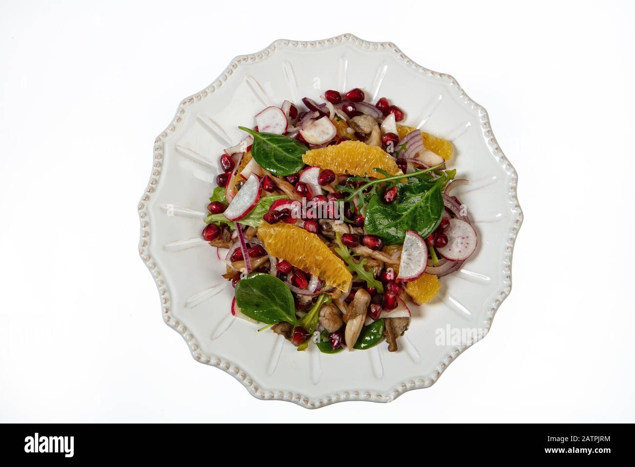 Insalata servita su un piatto di porcellana con fette di arancia, melograno, rucola e ostriche funghi, sfondo bianco, cibo, Russia Foto Stock