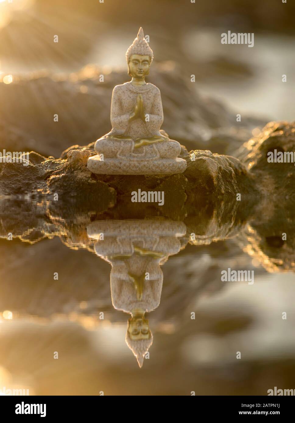 un buddha sulle rocce e il suo riflesso nell'acqua, manipolazione Foto Stock