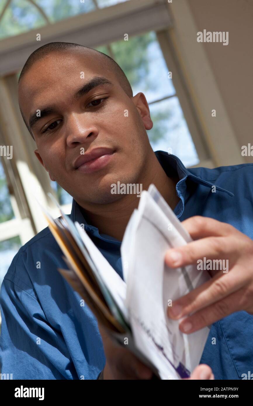 Giovane professionista maschile che guarda i documenti Foto Stock