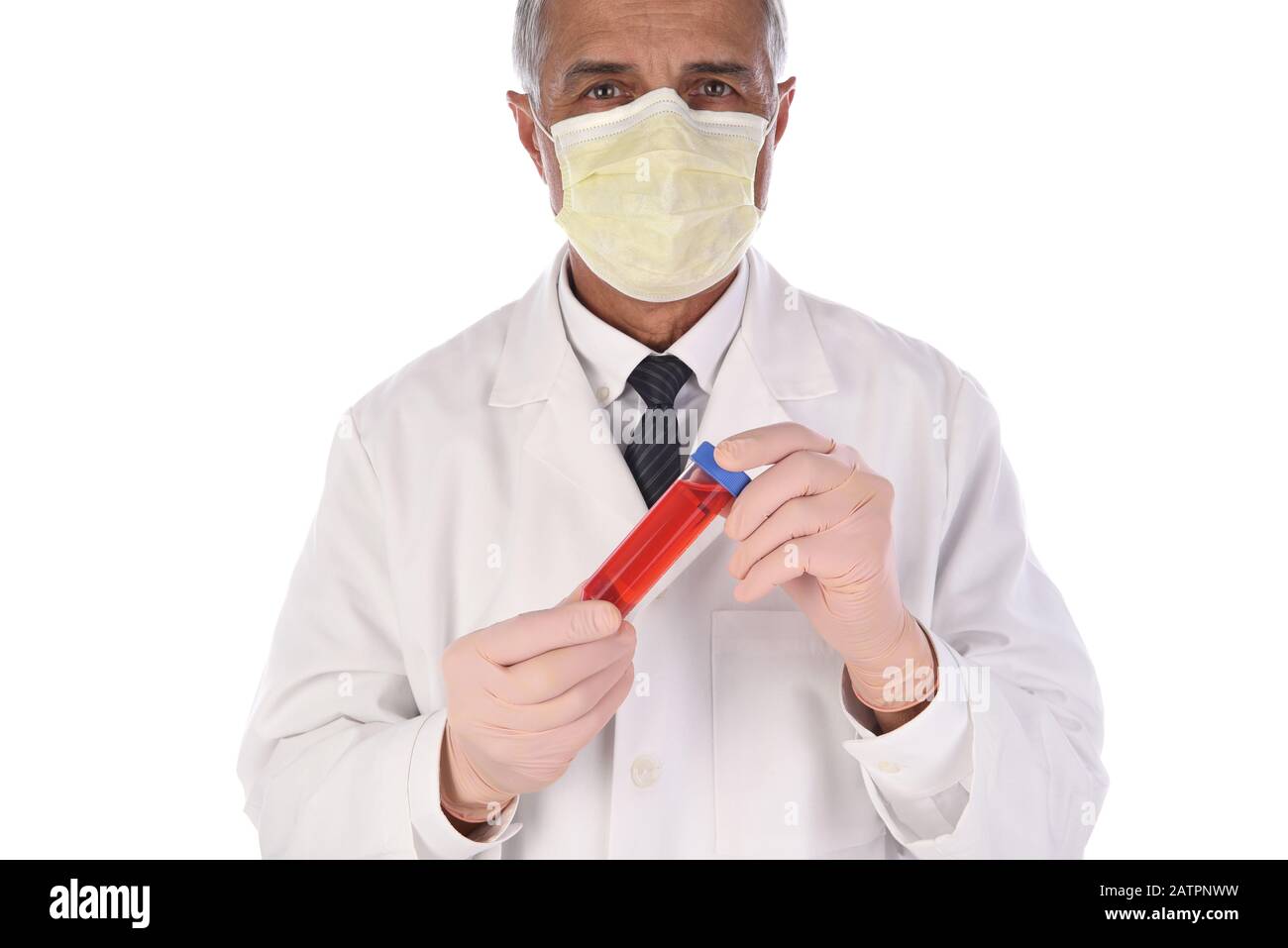 Tecnico di laboratorio che tiene una fiala di liquido rosso davanti al suo corpo. L'uomo indossa una maschera protettiva per prevenire le infezioni. Foto Stock