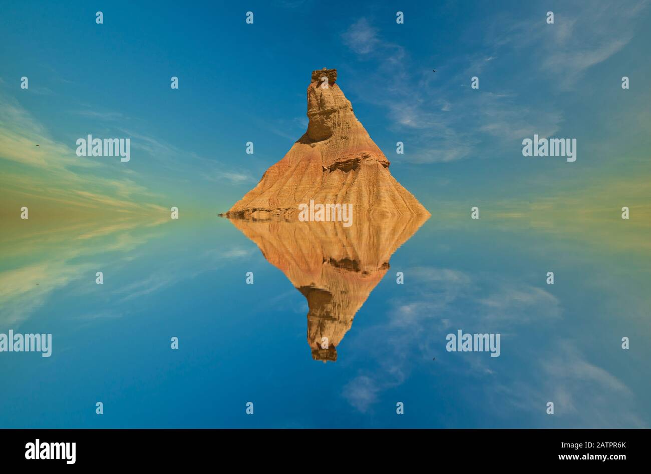 Riflessioni di una piccola collina nell'acqua sotto il cielo blu, montaggio Foto Stock