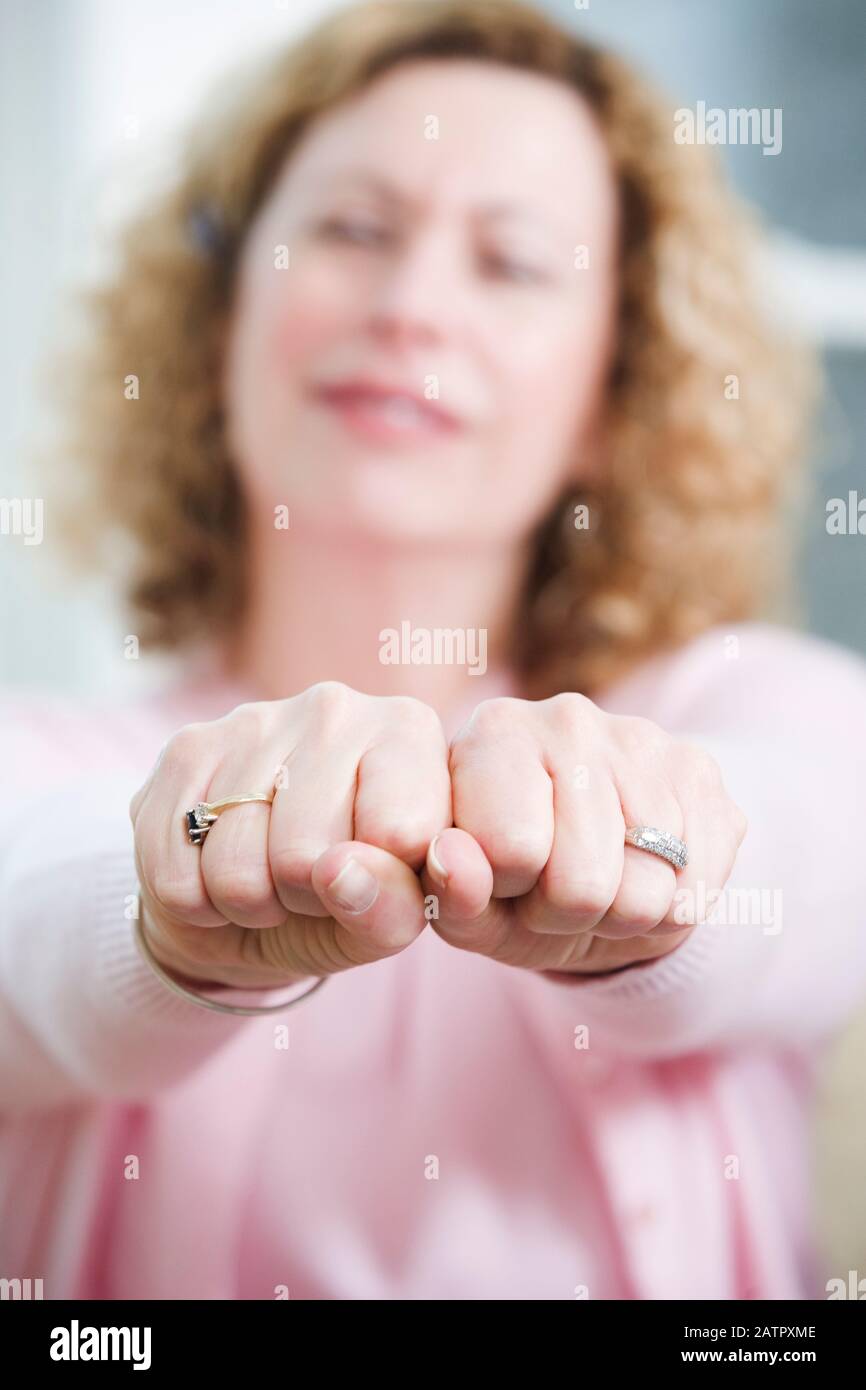 Vista di una donna matura che tiene insieme le mani per essere legato. Foto Stock