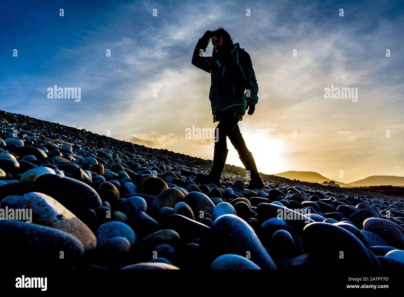 Ardara, Contea di Donegal, Irlanda. 4 febbraio 2020. Il sole invernale basso silhouette un camminatore sulla spiaggia 'Wild Atlantic Way'. Foto Stock