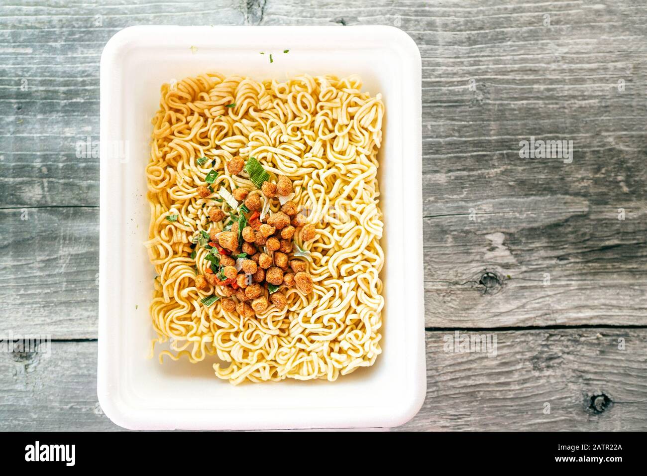 ciotola di minestra di ramen. Tom Yam kun noodles istantaneo con carne secca e additivi vegetali su un tavolo di legno. Zuppa rapida preparata a caldo in una confezione monouso Foto Stock