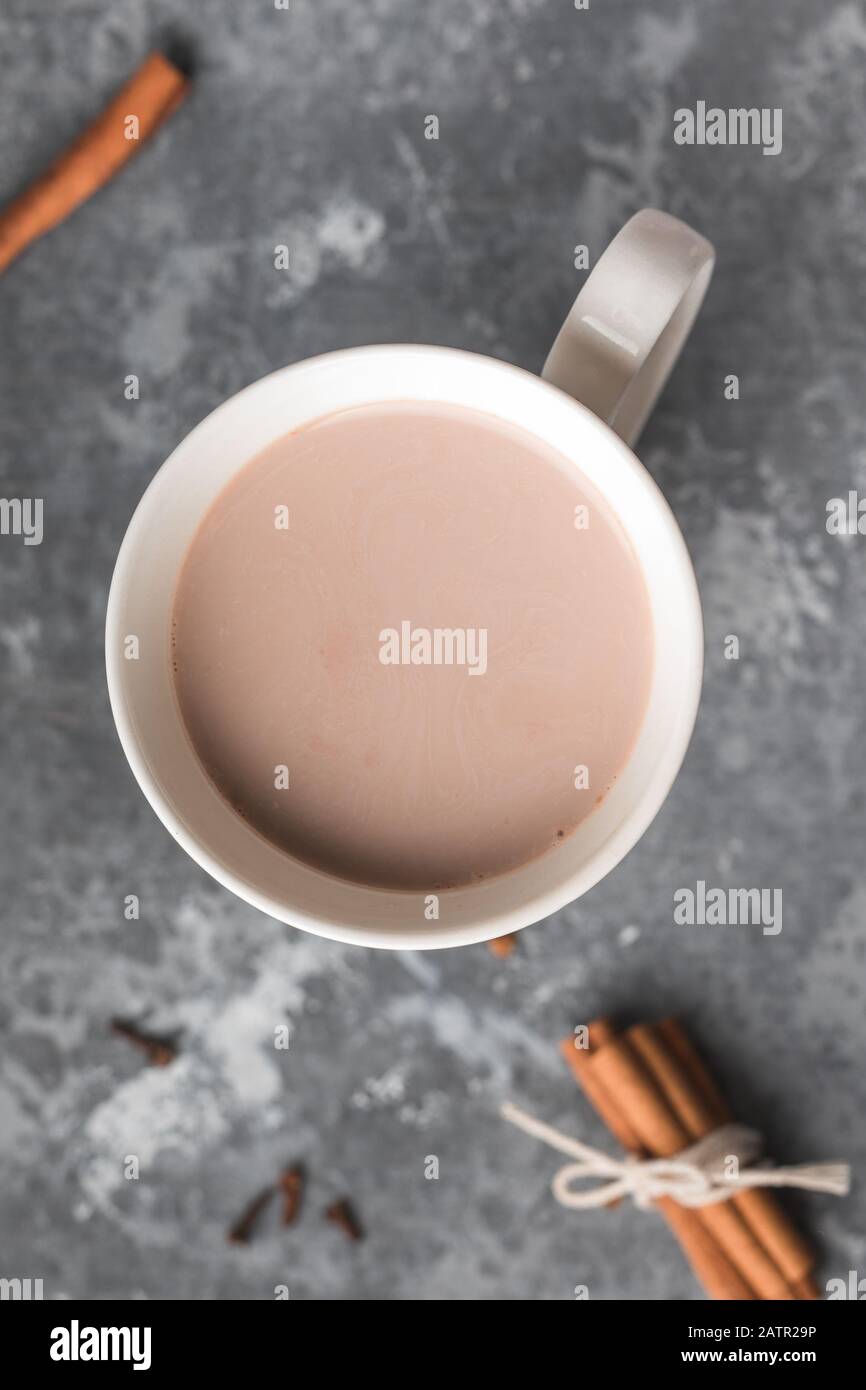 Una tazza bianca di bevanda calda al cacao con cannella Foto Stock