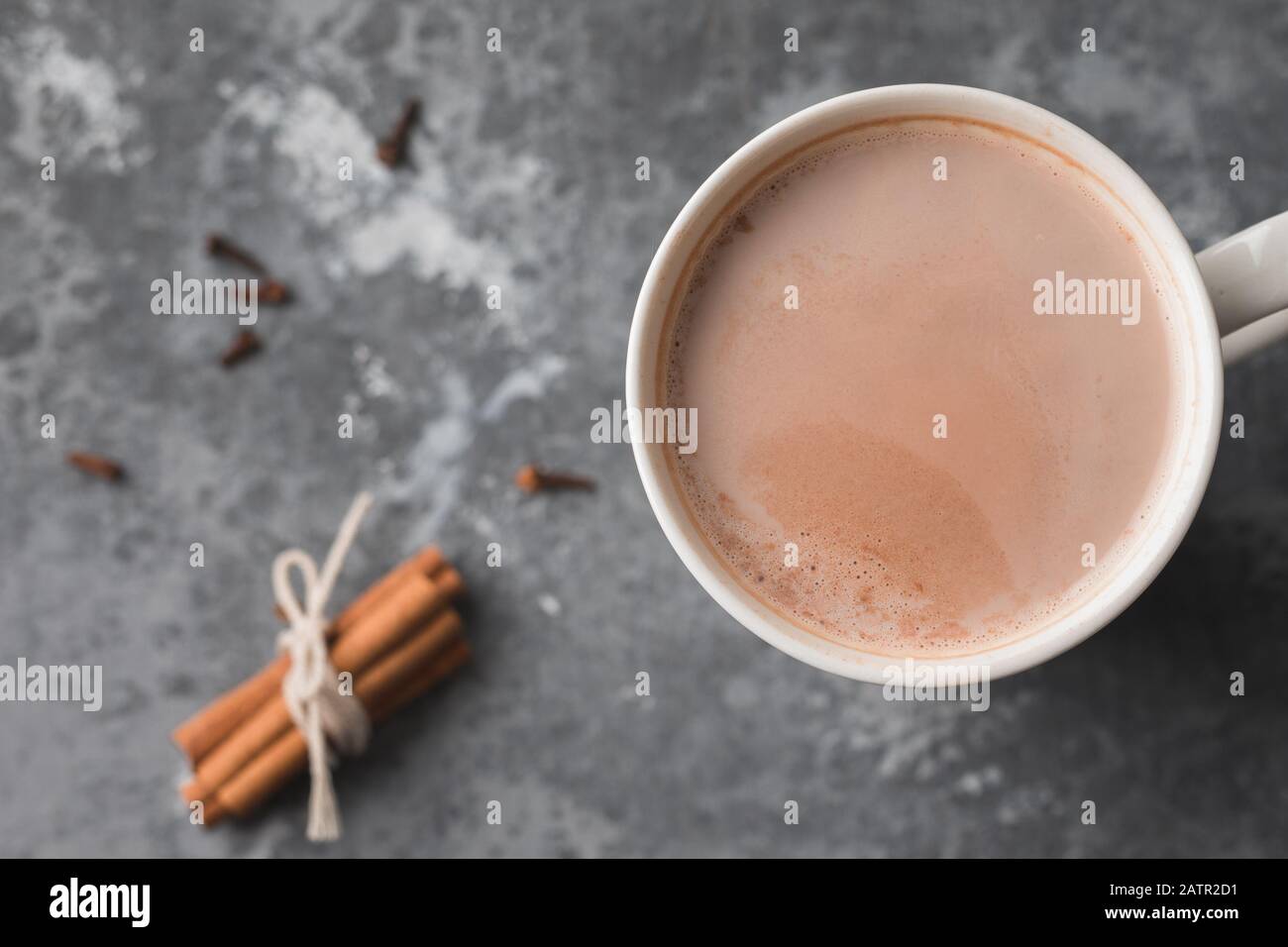 Una tazza bianca di bevanda calda al cacao con cannella Foto Stock