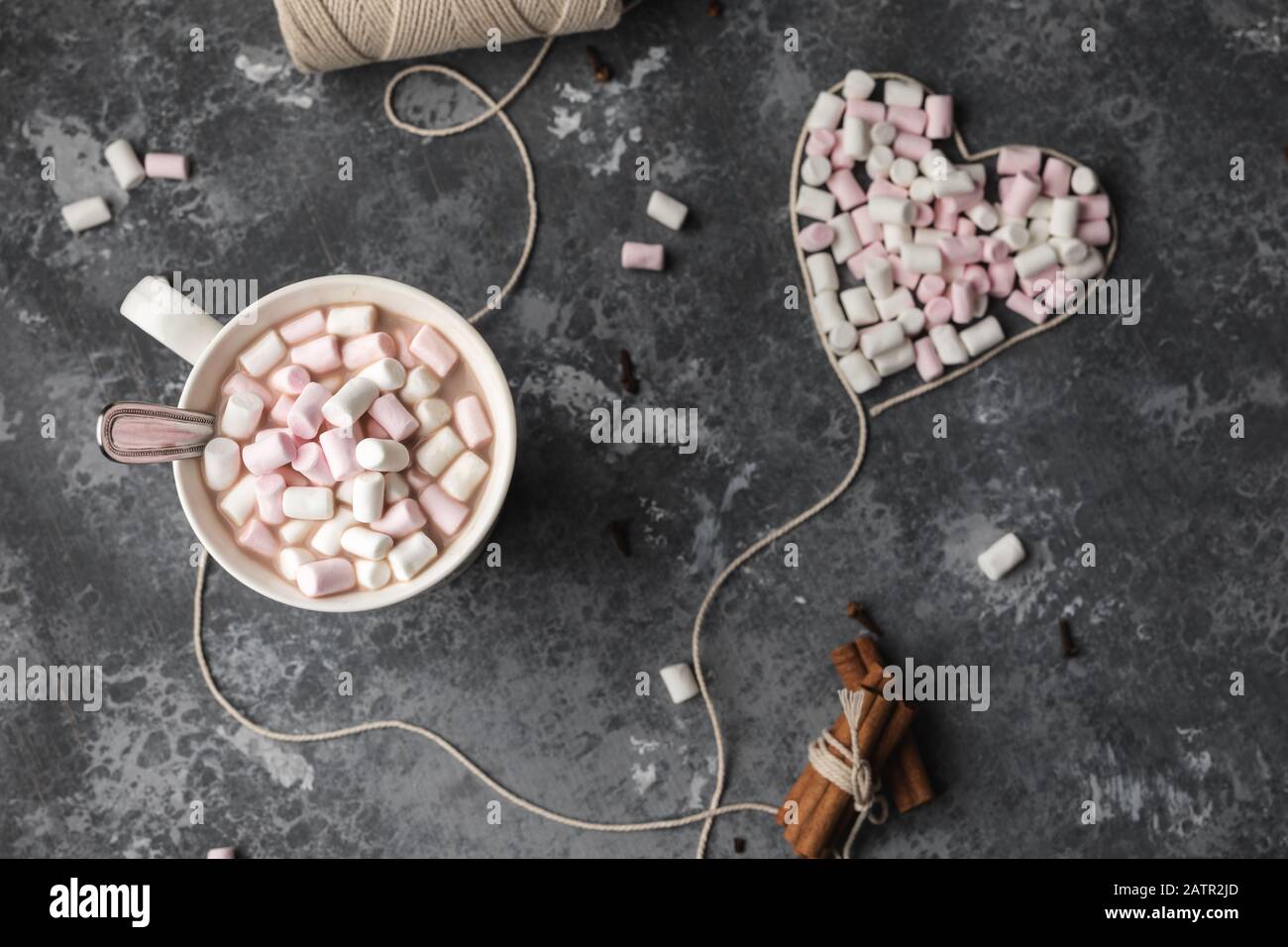 Una tazza di cacao caldo con cuore di filato di cotone bianco per San Valentino pieno di marshmallows Foto Stock
