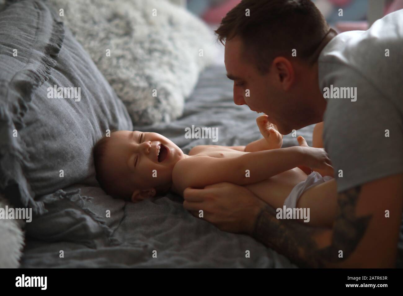 Padre ha un divertimento e gioca con la sua piccola figlia. Il bambino ride allegramente. Foto Stock