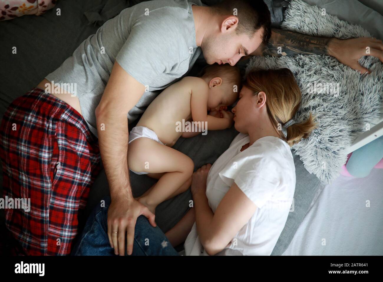 Famiglia con bambino dorme insieme sul letto. Vista dall'alto. Foto Stock