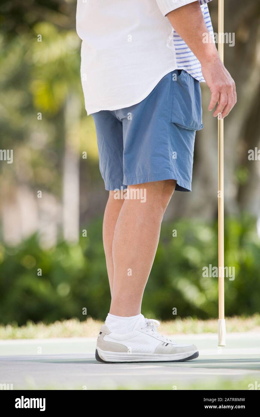 Bassa vista in sezione di un anziano uomo giocando shuffleboard Foto Stock