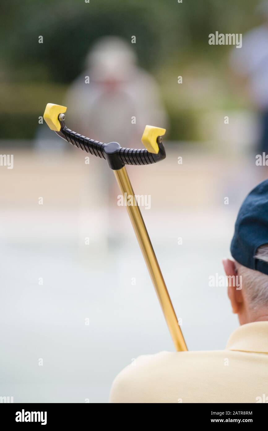 Vista posteriore di un anziano uomo tenendo un shuffleboard cue Foto Stock