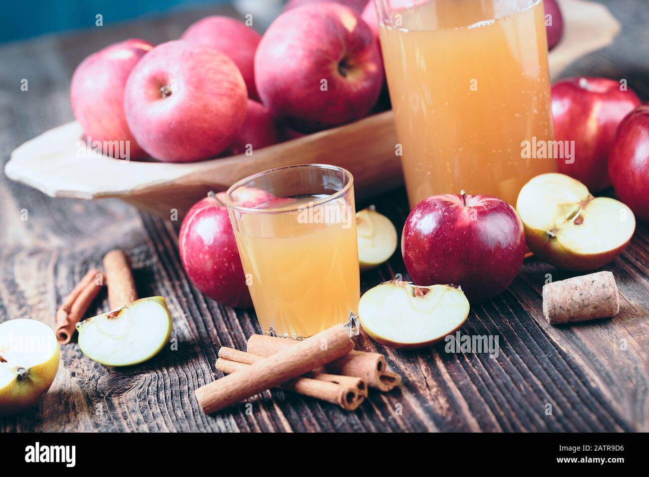 Sidro di mele o succo di mele fresco biologico con cannella sul vecchio tavolo di legno. Foto Stock