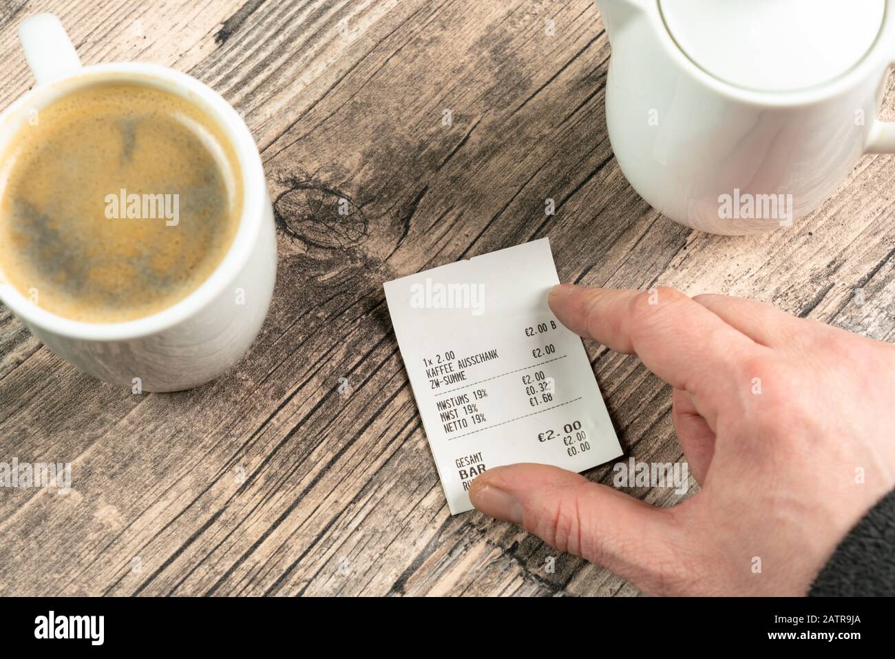 consegnare una ricevuta su un tavolo con una tazza di caffè Foto Stock