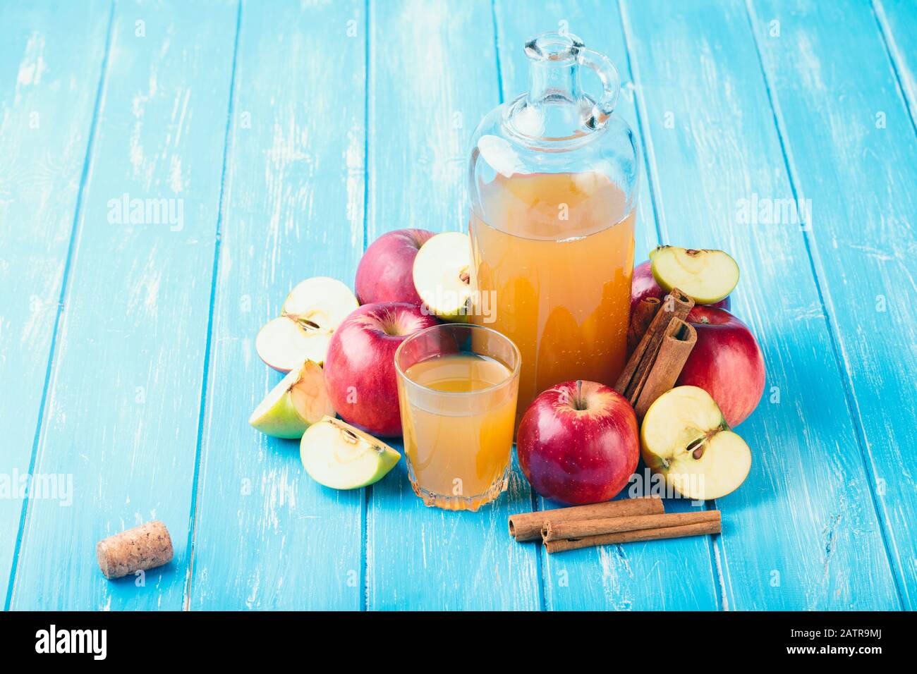 Sidro di mele fresco biologico o succo di mela con sullo sfondo blu. Foto Stock