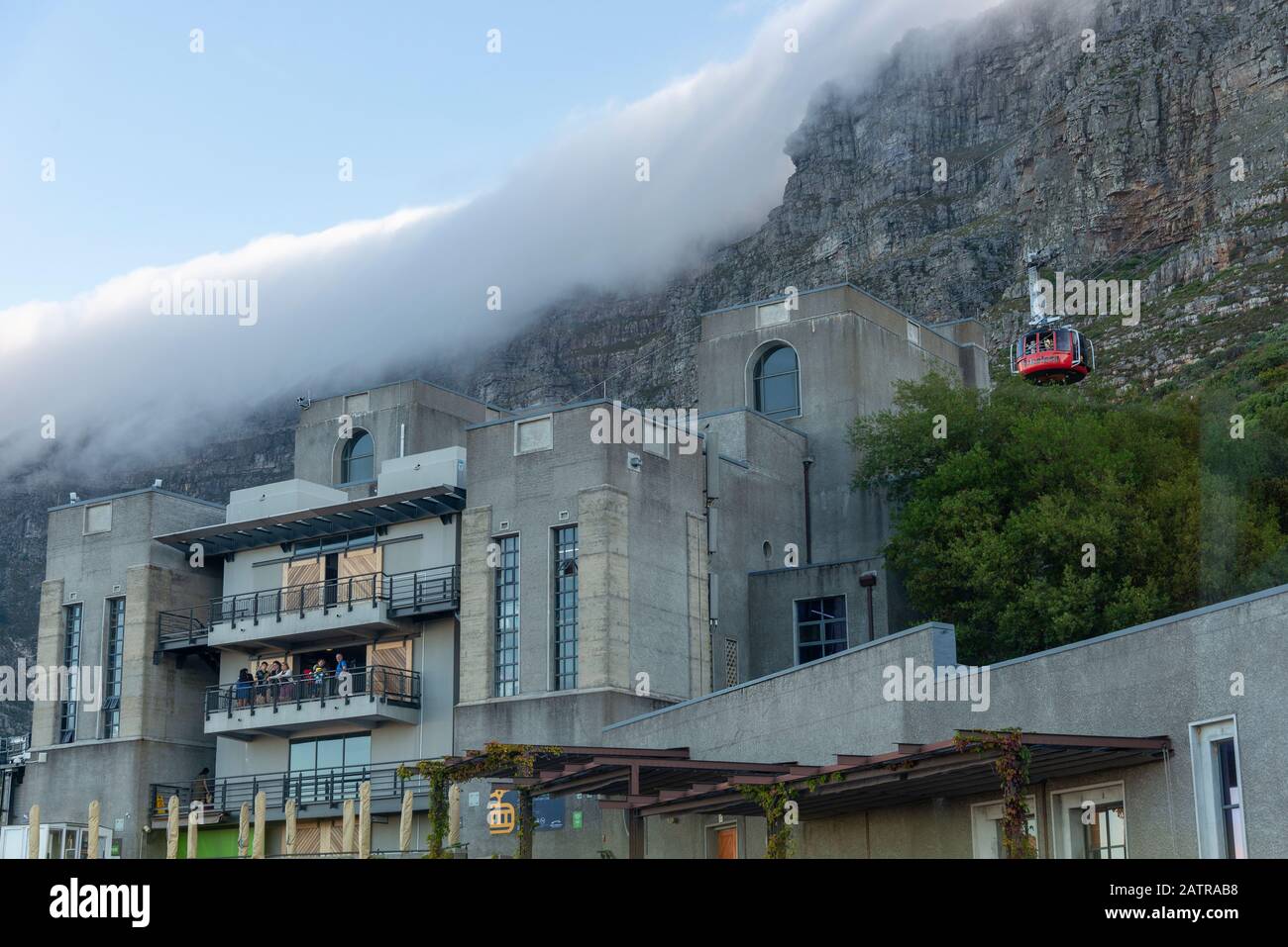 Table Mountain Aerial Cableway stazione inferiore, con un bianco 'tovaglia 'nubi di stoffa che si piega sopra la cima della montagna, Città del Capo, Sud Africa Foto Stock