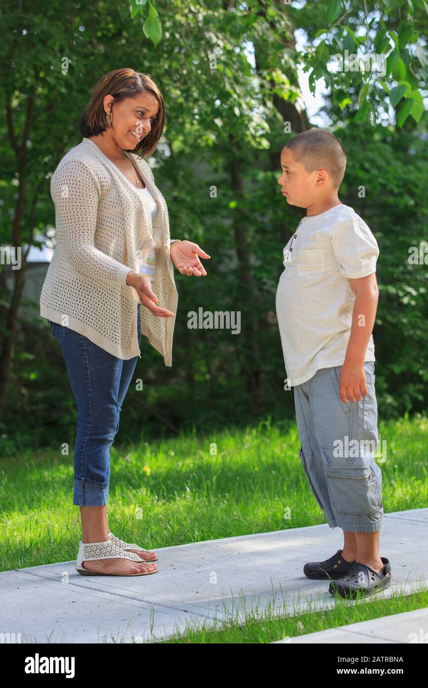Madre che parla con il figlio pre-teen su un percorso all'aperto Foto Stock