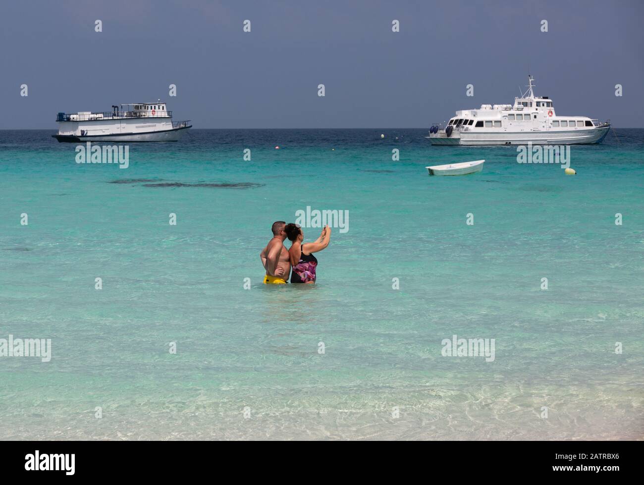 Maldive vacanze - una coppia di mezza età scattare una foto selfie nell'Oceano Indiano su una spiaggia nelle Maldive, in Asia Foto Stock