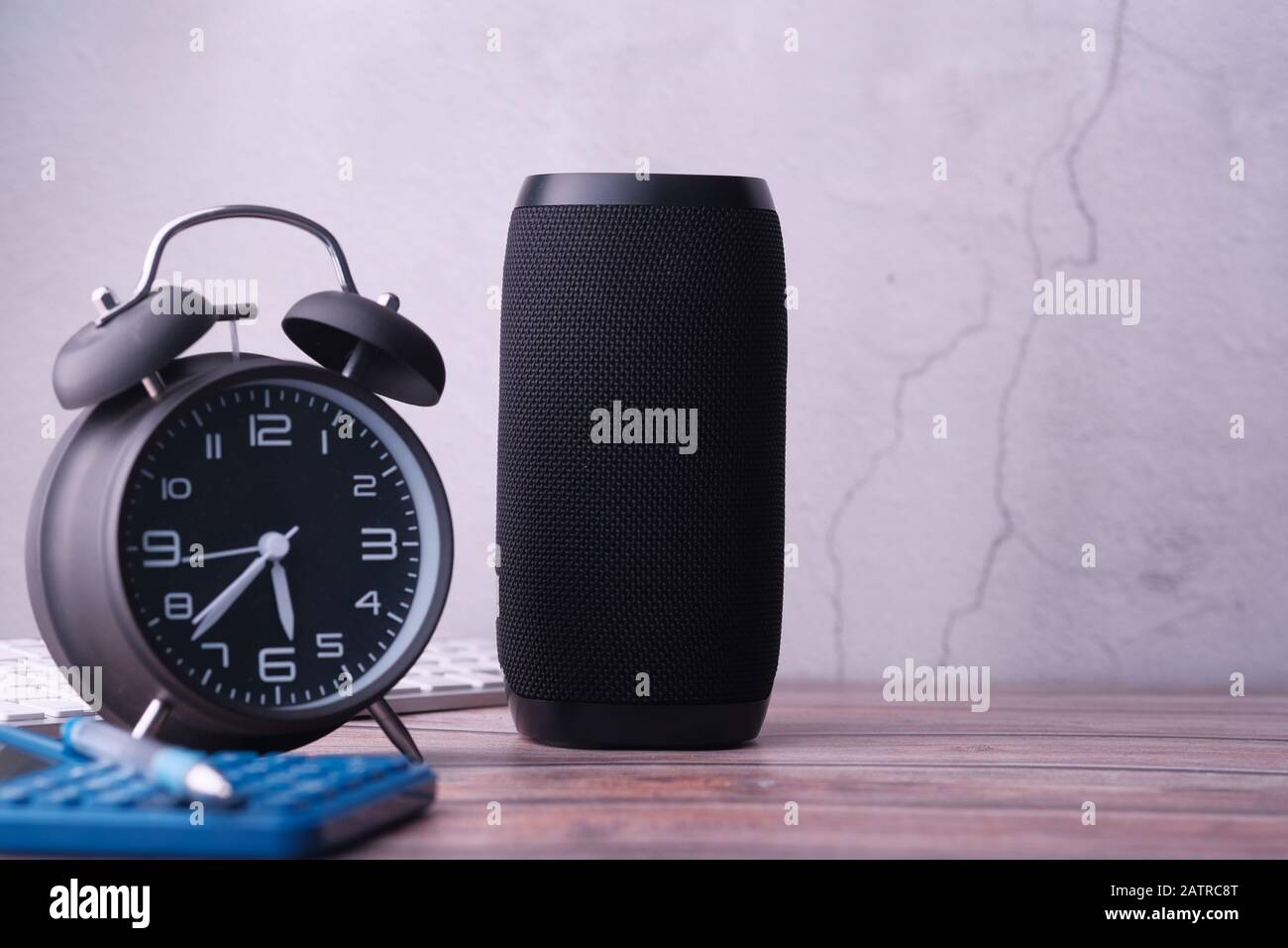 altoparlante intelligente con orologio sul tavolo contro una parete Foto Stock