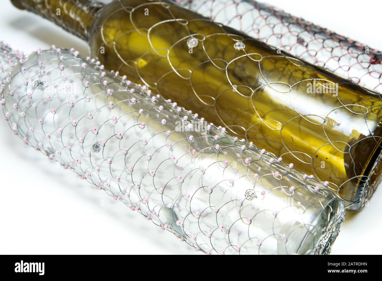 Le tre diverse bottiglie di vino a filo spazzolato. Il tradizionale artigianato decorativo. Su sfondo bianco. Foto Stock
