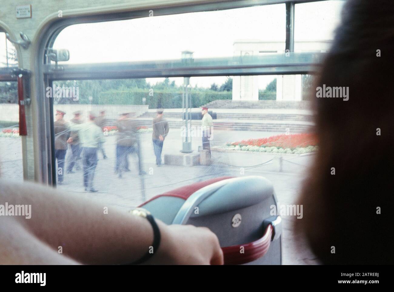 Soldati e civili sono visibili in un checkpoint a Berlino Ovest, Germania, visto attraverso la finestra di un autobus turistico, 1970. () Foto Stock
