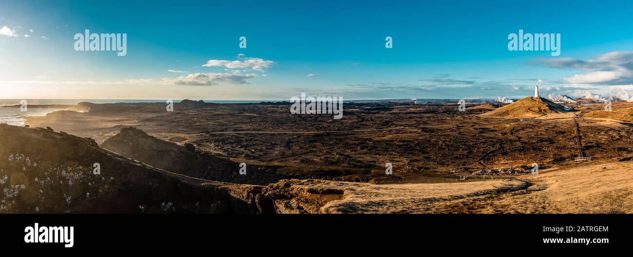 Vasto paesaggio islandese e faro di Reykjanes in lontananza, il faro più antico d'Islanda, sulla collina di Baejarfell, Penisola di Reykjanes; Islanda Foto Stock