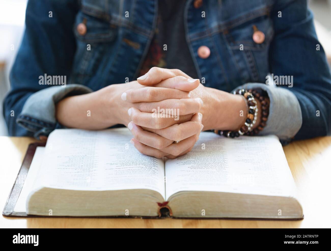 Una donna matura pregando, dopo aver fatto un po' di studio biblico personale, in un coffee shop : Edmonton, Alberta, Canada Foto Stock