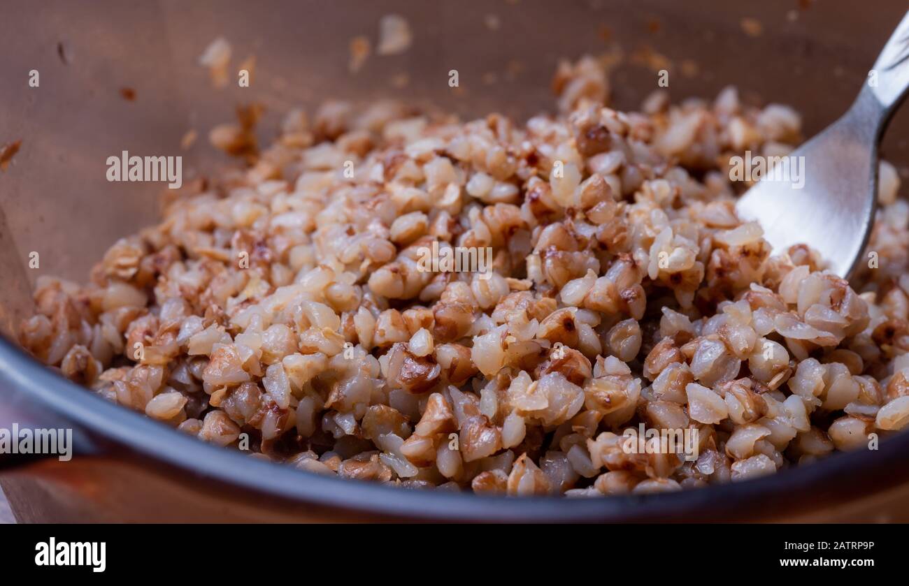 porridge di grano saraceno e forchetta sul tavolo marrone . Colazione gustosa e sana Foto Stock