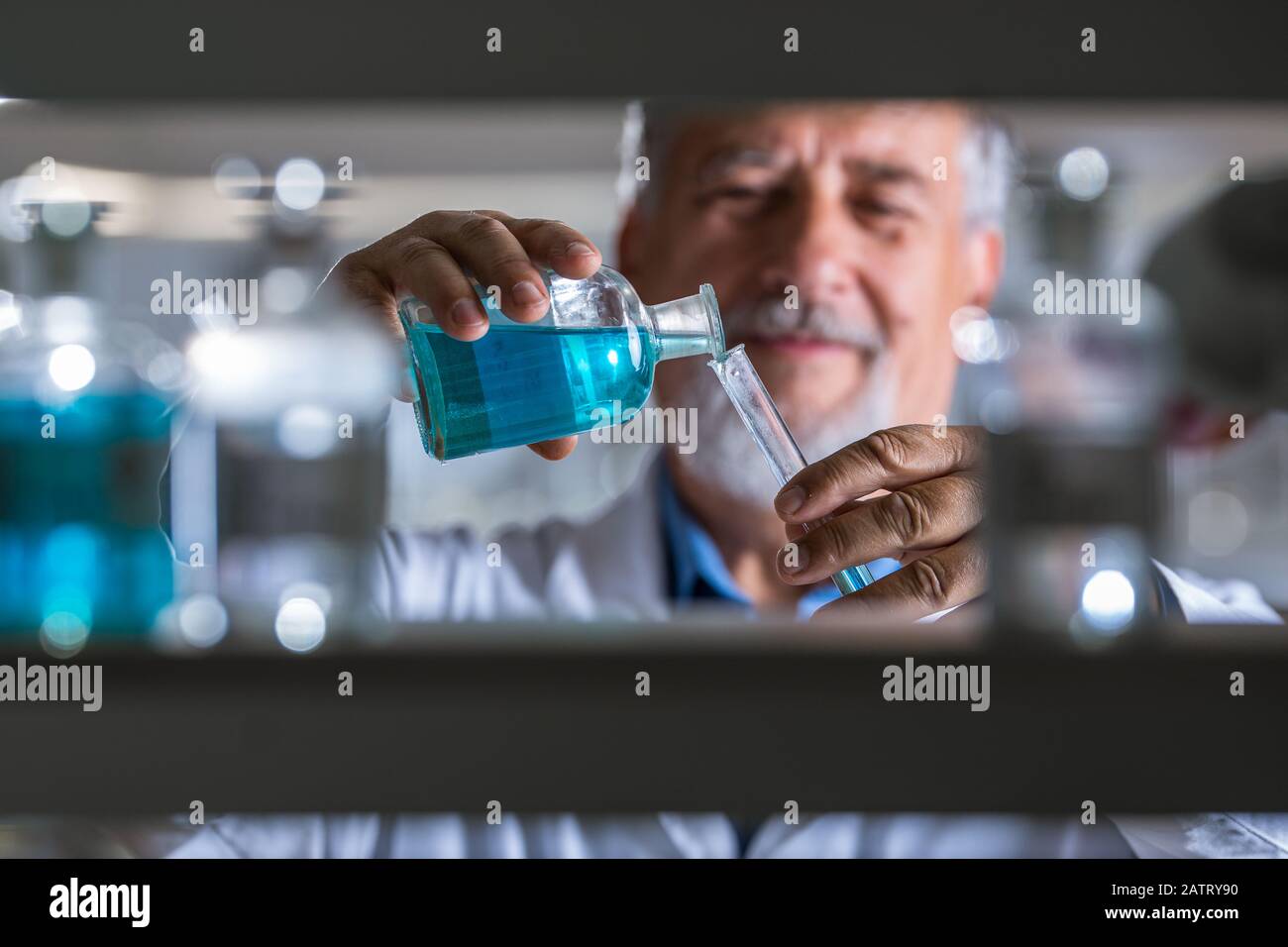 Maschio senior researcher di effettuare attività di ricerca scientifica in un laboratorio (SHALLOW DOF; dai toni di colore immagine) Foto Stock