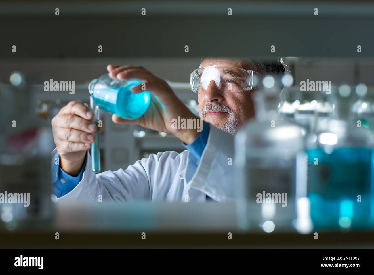 Maschio senior researcher di effettuare attività di ricerca scientifica in un laboratorio (SHALLOW DOF; dai toni di colore immagine) Foto Stock
