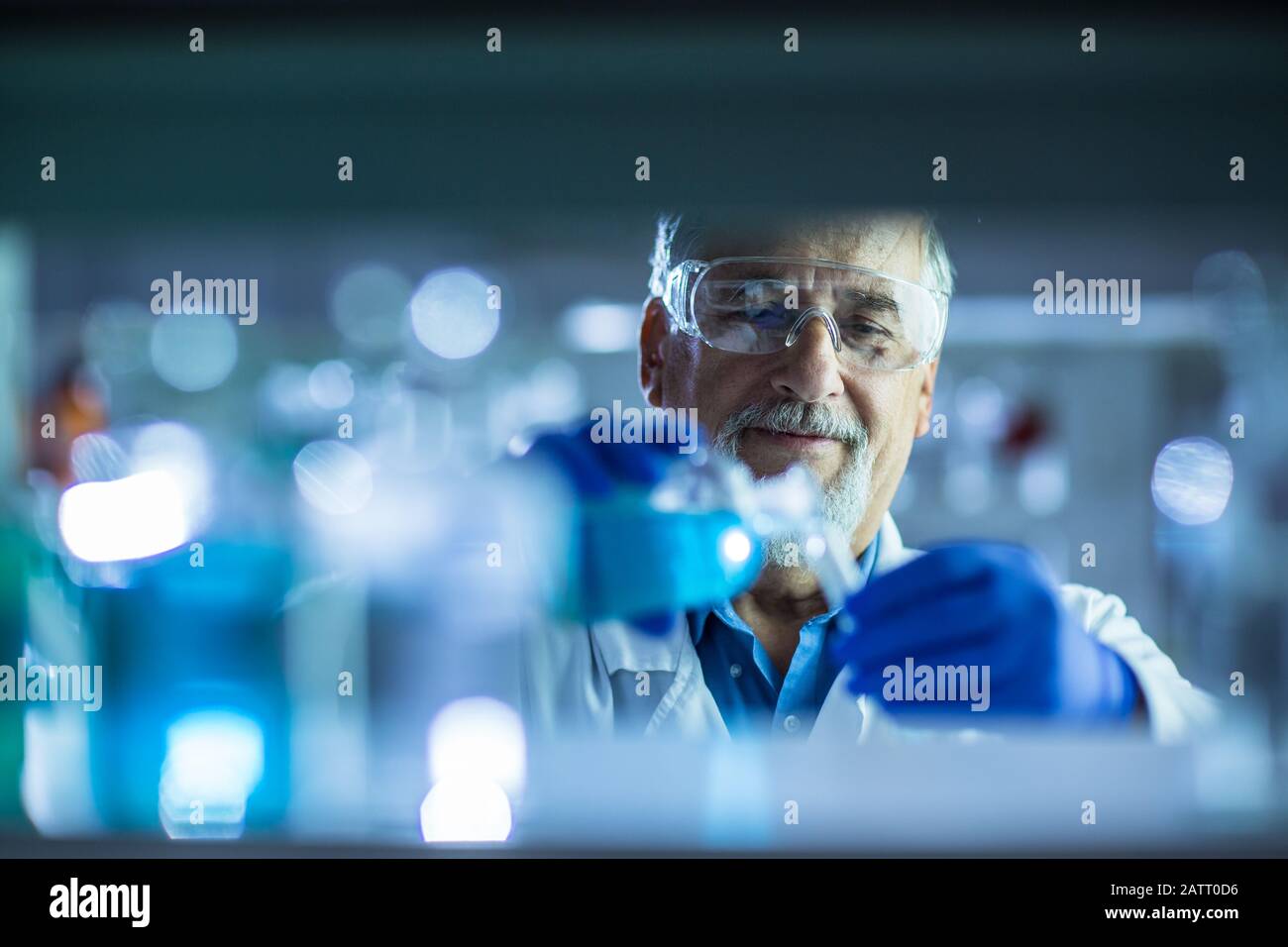 Maschio senior researcher di effettuare attività di ricerca scientifica in un laboratorio (SHALLOW DOF; dai toni di colore immagine) Foto Stock