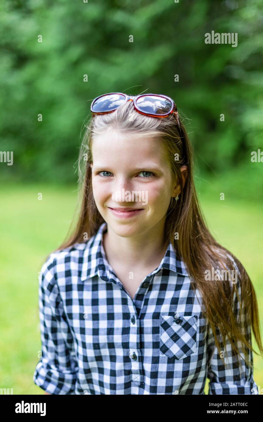 Ritratto di una ragazza pre-teen in piedi sull'erba in un parco; Salmon Arm, British Columbia, Canada Foto Stock