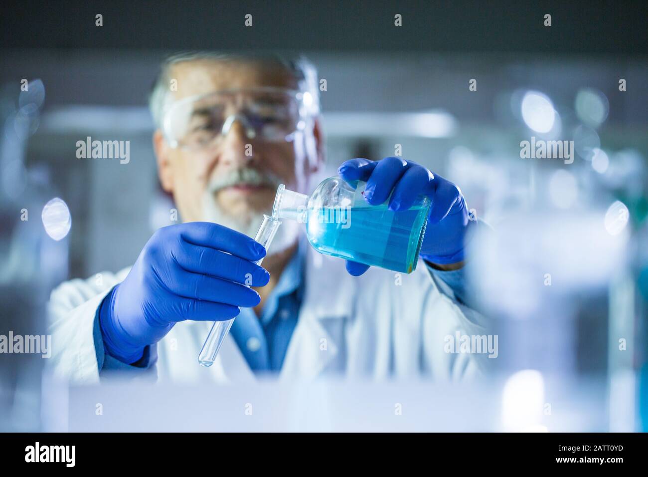 Maschio senior researcher di effettuare attività di ricerca scientifica in un laboratorio (SHALLOW DOF; dai toni di colore immagine) Foto Stock