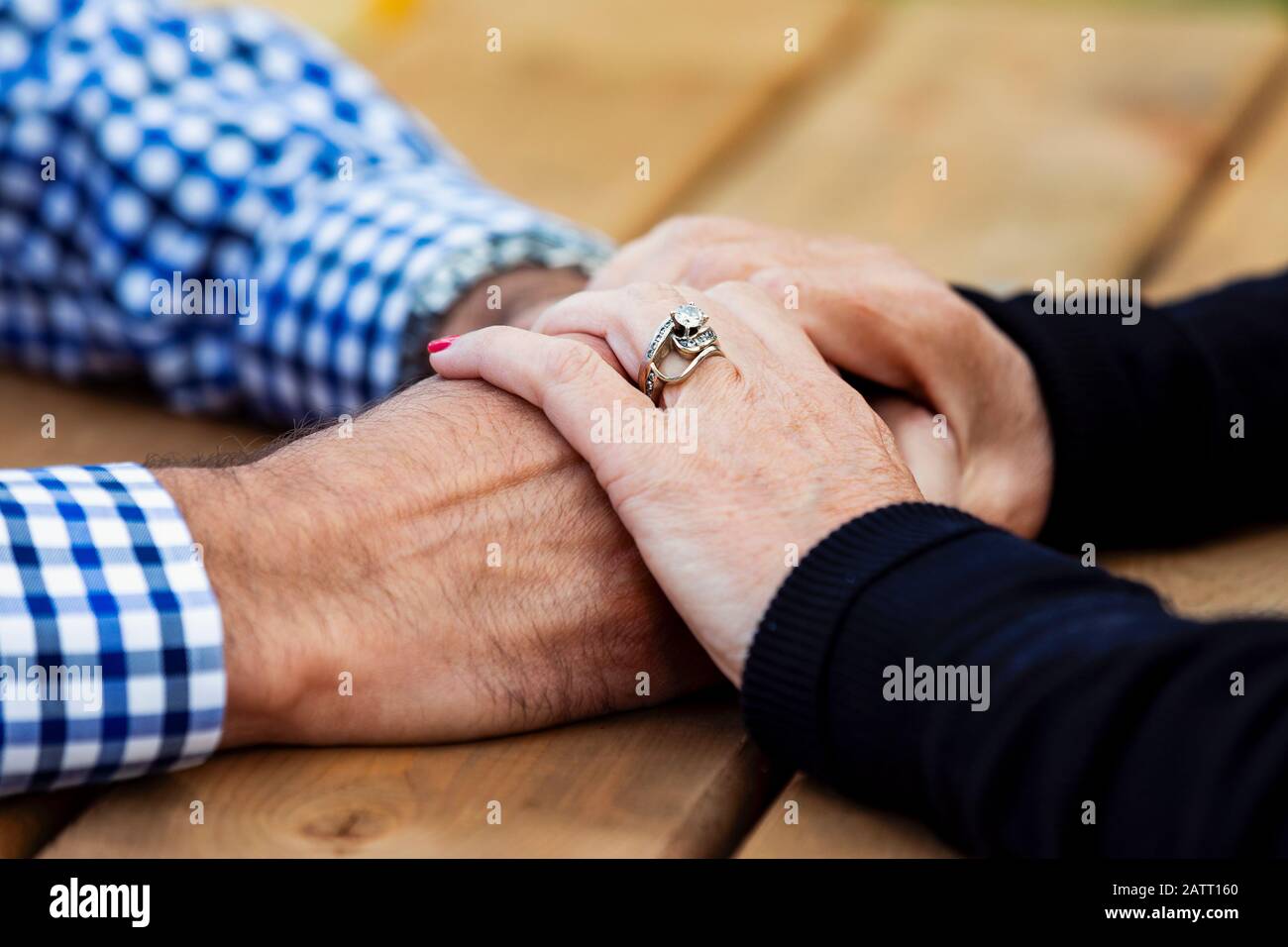 Una coppia matura che prega insieme ad un tavolo da picnic dopo aver trascorso un po' di tempo di qualità a discutere la loro fede; St. Albert, Alberta, Canada Foto Stock