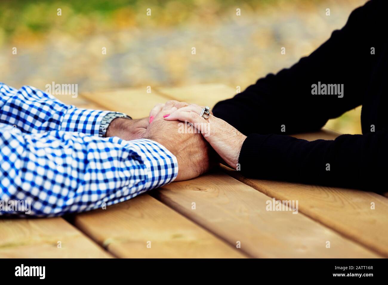 Una coppia matura che prega insieme ad un tavolo da picnic dopo aver trascorso un po' di tempo di qualità a discutere la loro fede; St. Albert, Alberta, Canada Foto Stock