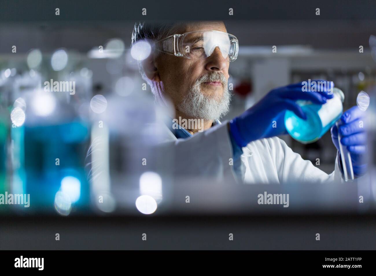 Maschio senior researcher di effettuare attività di ricerca scientifica in un laboratorio (SHALLOW DOF; dai toni di colore immagine) Foto Stock