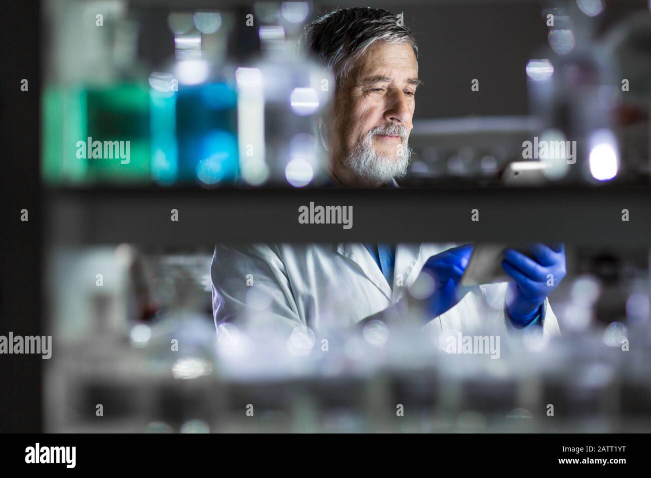 Maschio senior researcher di effettuare attività di ricerca scientifica in un laboratorio (SHALLOW DOF; dai toni di colore immagine) Foto Stock