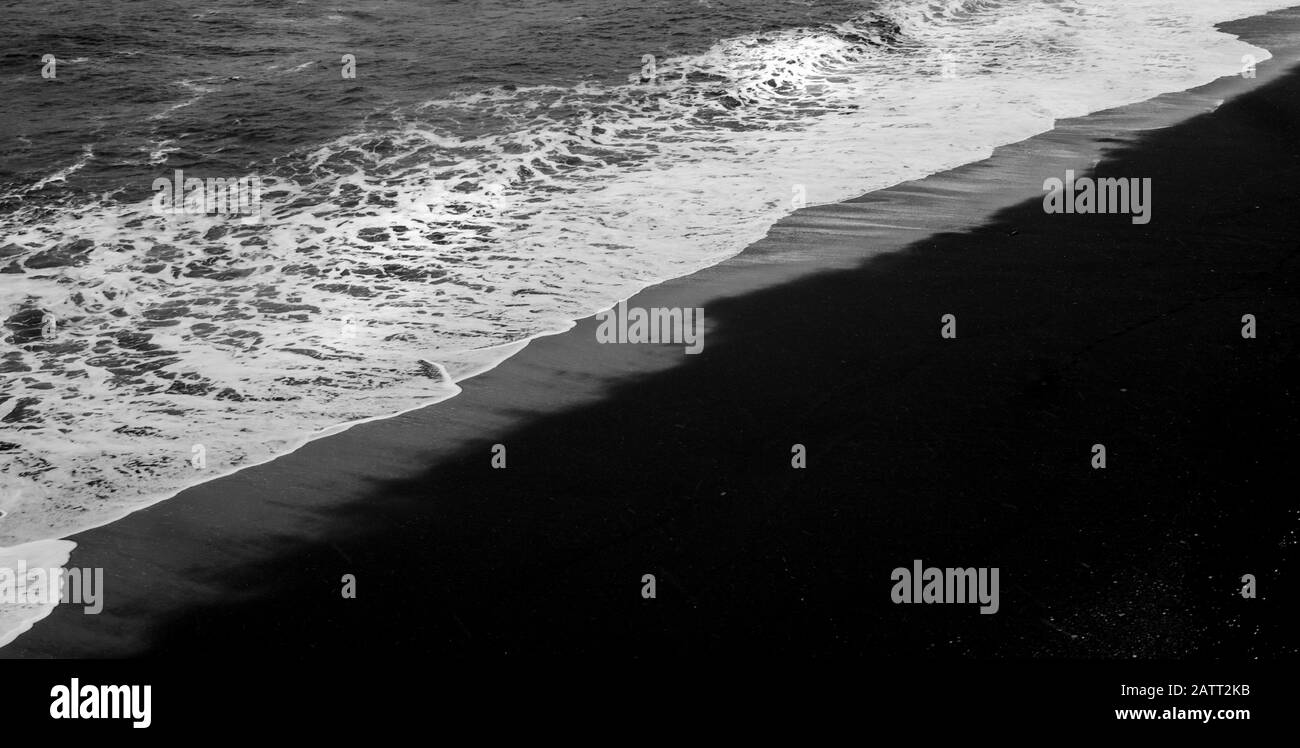 Spiaggia di sabbia nera costa e onde di mare. Vik villaggio Islanda Foto Stock