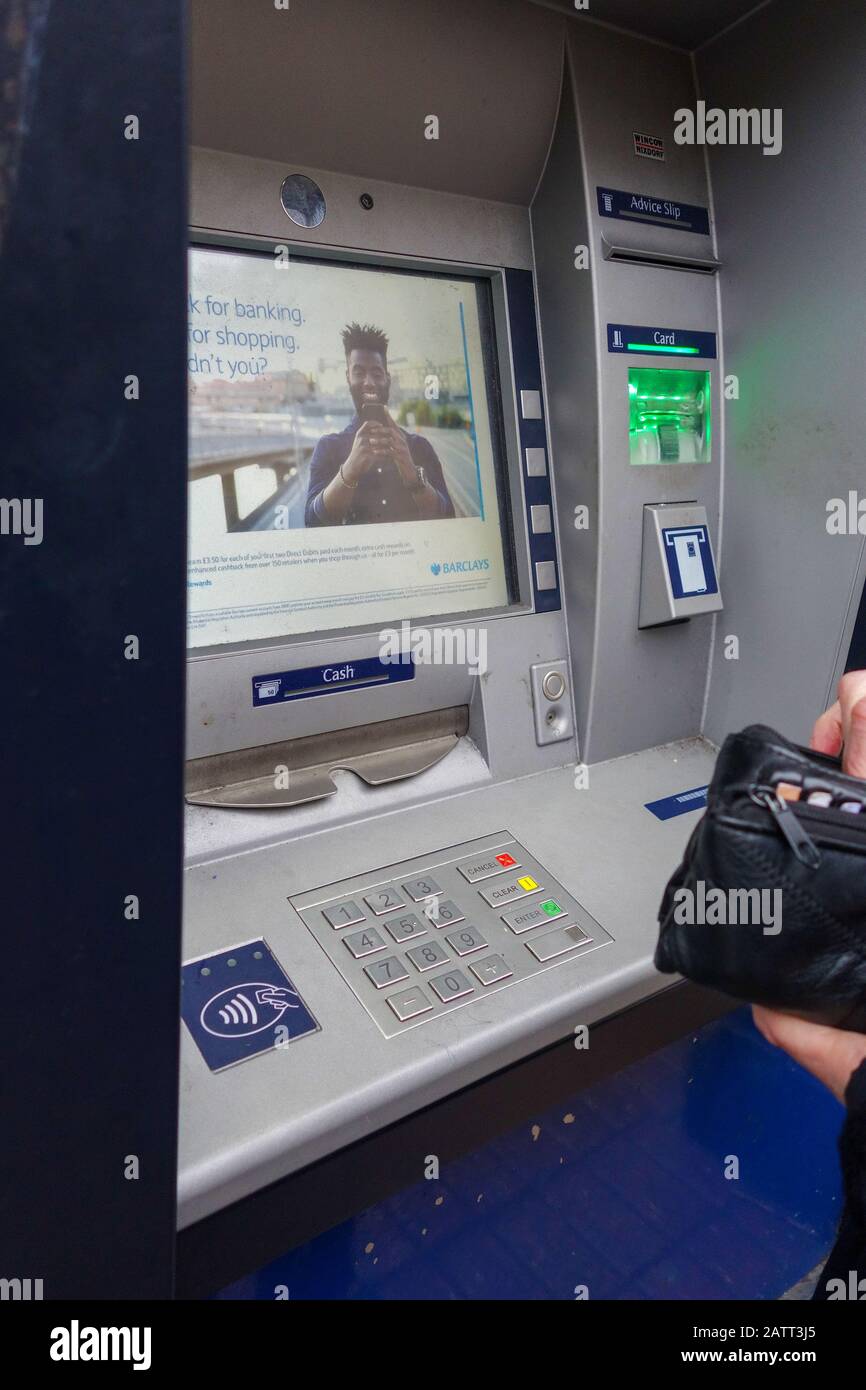 Qualcuno che sta per usare una macchina di contanti, una macchina automatica di Teller o ATM, Inghilterra, Regno Unito Foto Stock