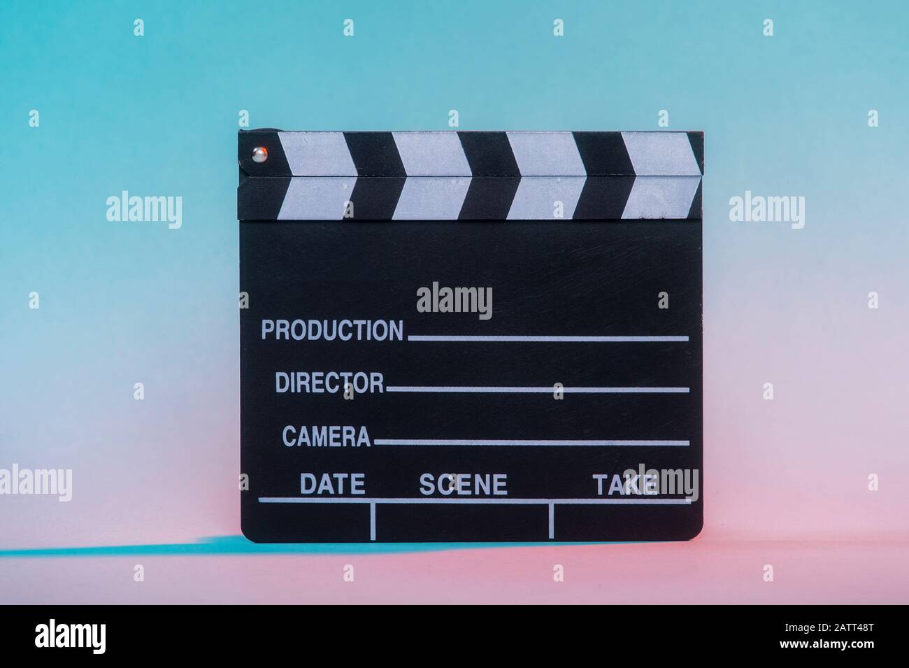 Film clapper su sfondo neon, concetto di cinema. Foto Stock