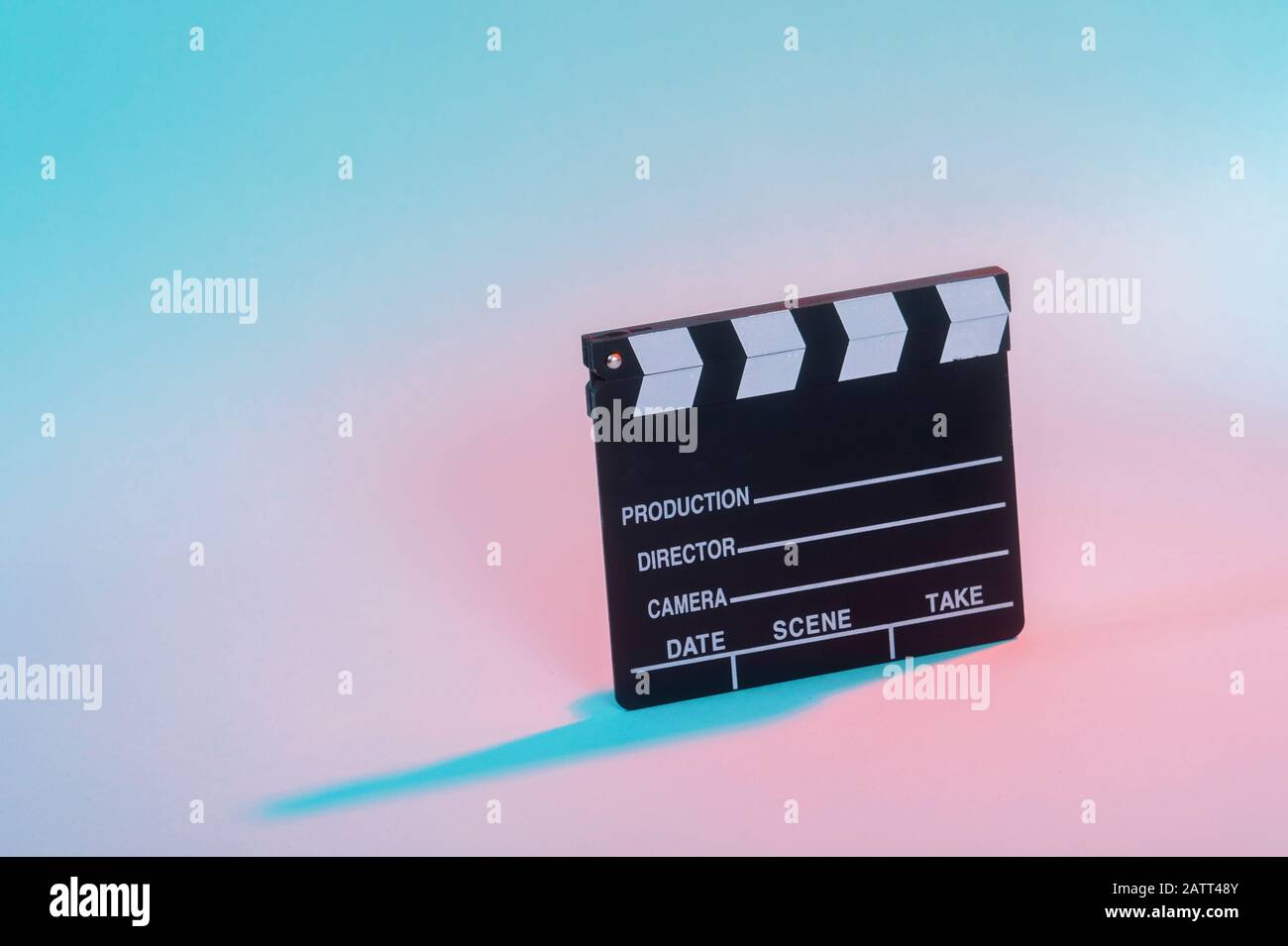 Film clapper su sfondo neon, concetto di cinema. Foto Stock