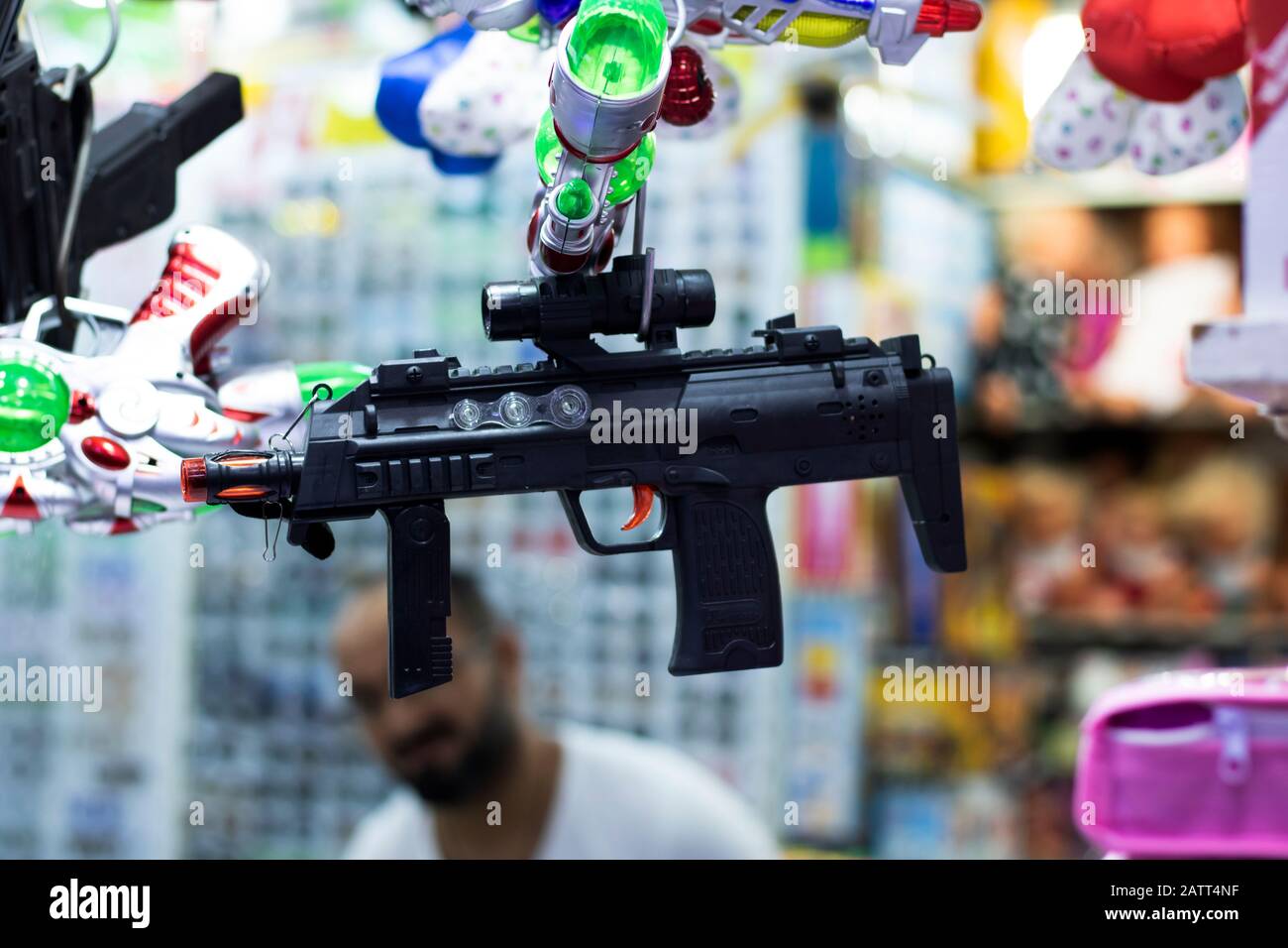 Arma automatica giocattolo in plastica. Lancia i cordoni di plastica. Fotografato appeso di fronte al negozio. Primo piano Foto Stock