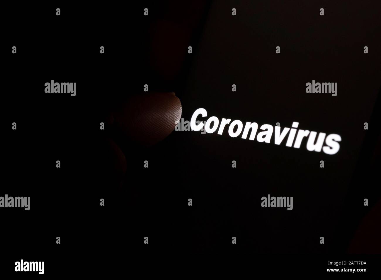 Parola "coronavirus" che si illumina su uno schermo nero e punta la punta della punta. Concetto di lutto e di essere sotto i riflettori. Foto Stock